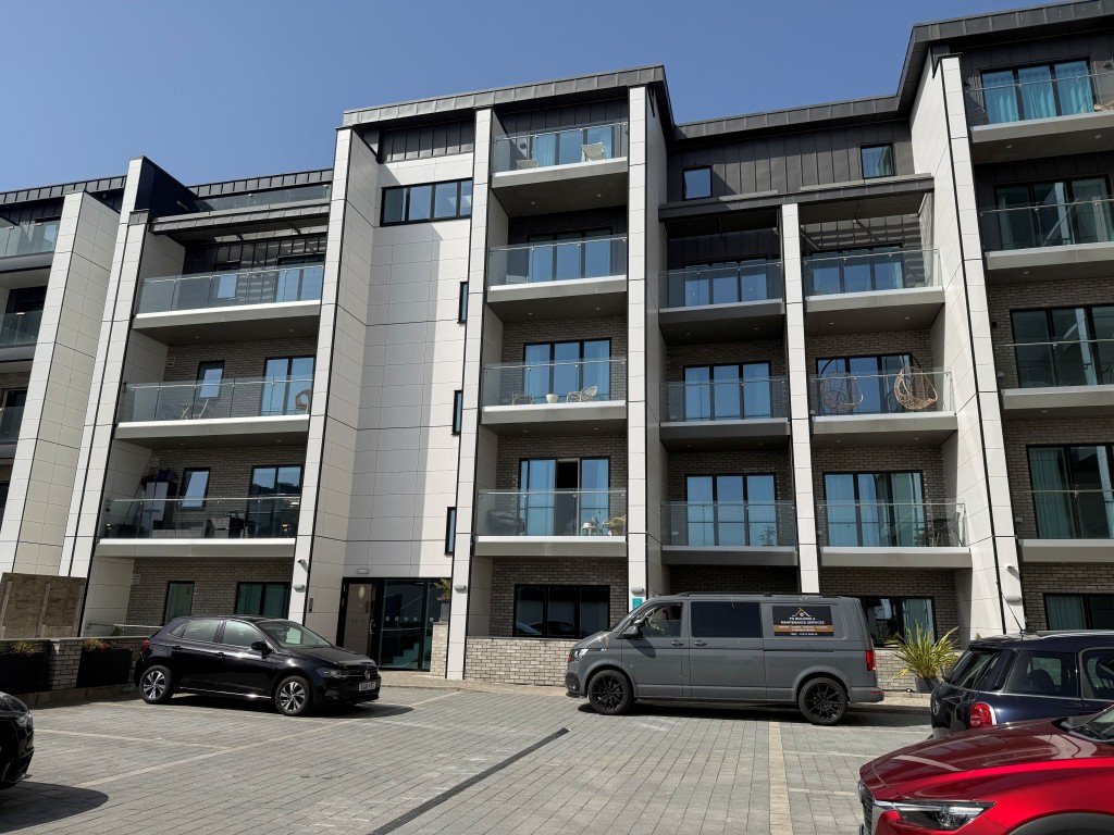 Lot: 132 - SPACIOUS TWO-BEDROOM APARTMENT WITH STUNNING SEA VIEWS AND PARKING - Rear elevation taken from parking area